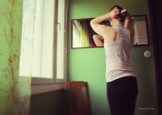 Woman is having a break from cleaning and looking herself on the mirror