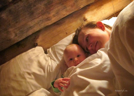 Baby and mother in bed in cottage