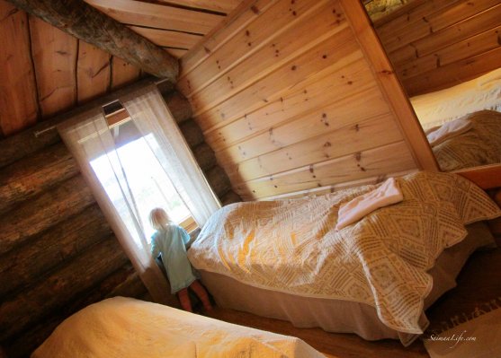 Little girl watching out cottage bedroom window