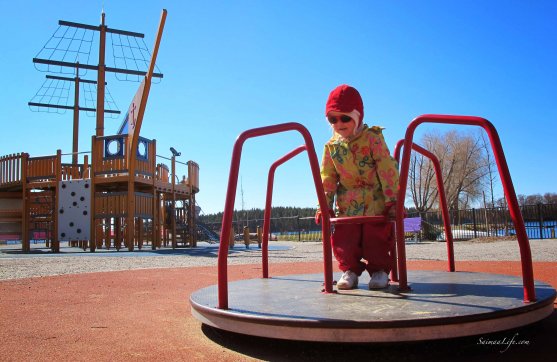 small girl in carousel on playground