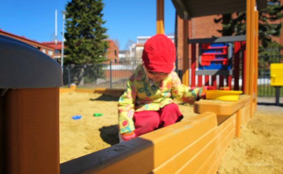 young girl playing in sand box