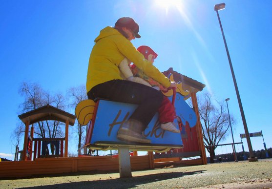 mom and daughter riding wooden horse playground