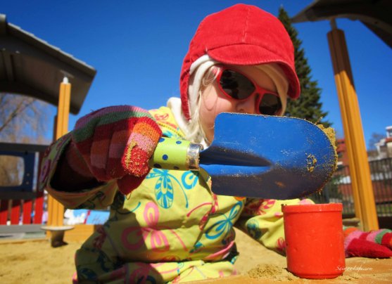 girl making sandcakes at the playground