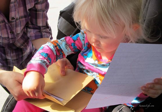 child-putting-drawing-to-envelope