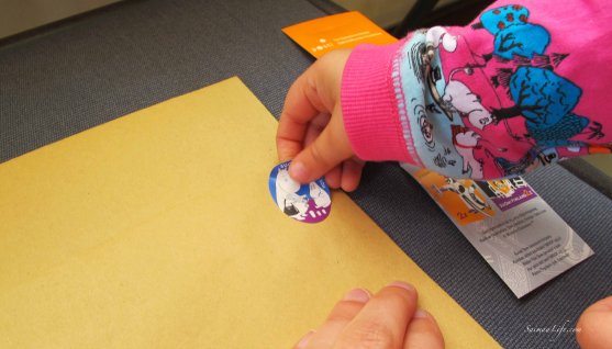 child-putting-moomin-stamp