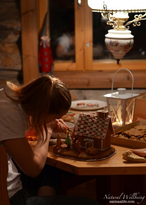 mother-decorating-christmas-gingerbread-house