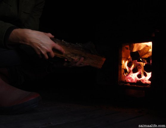 woman-adding-wood-to-sauna