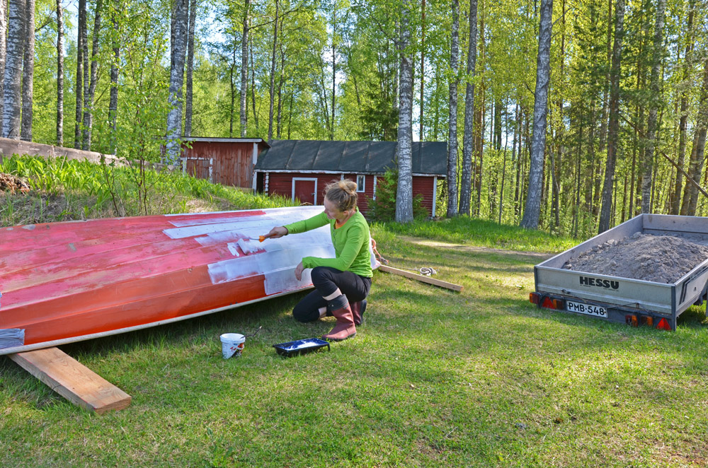 woman-painting-boat-outdoors