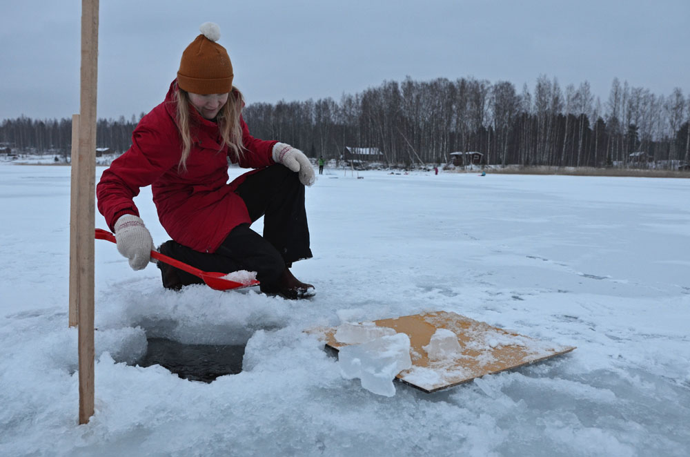 Making a hole in the ice before winter fishing - SaimaaLife.com