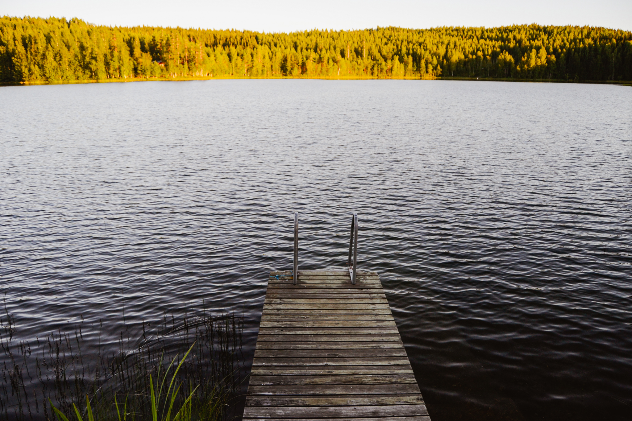 dock by the Finnish lake on calm summer evening