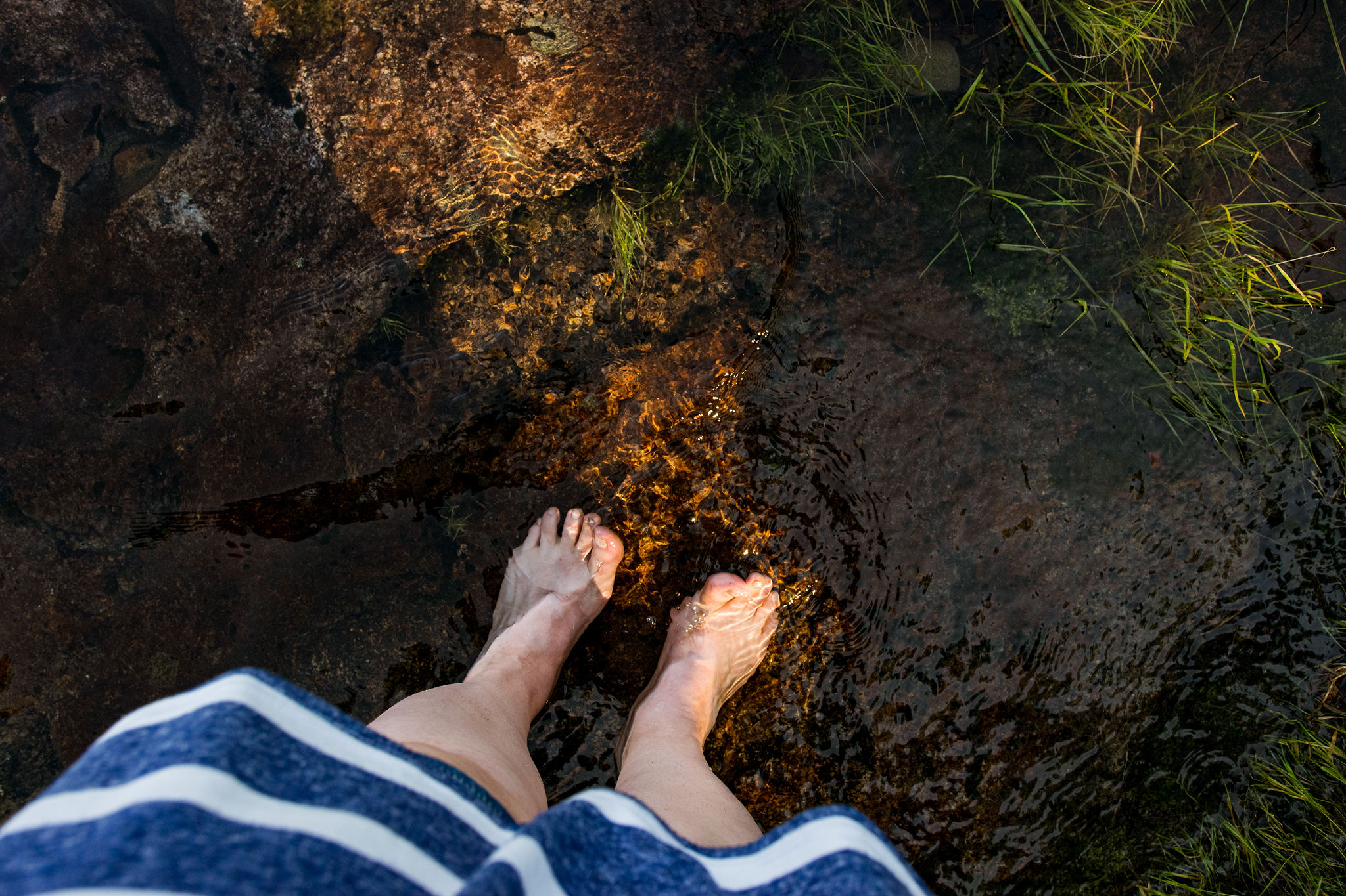 finnish woman relaxing barefoot on clear saimaa lake water