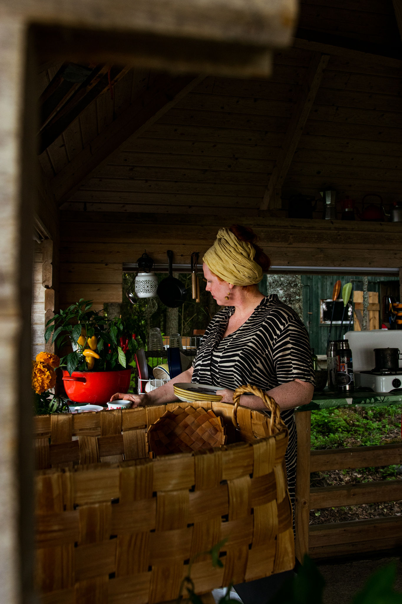 woman preparing grilling food in outdoor kitchen at summer cottage in saimaa