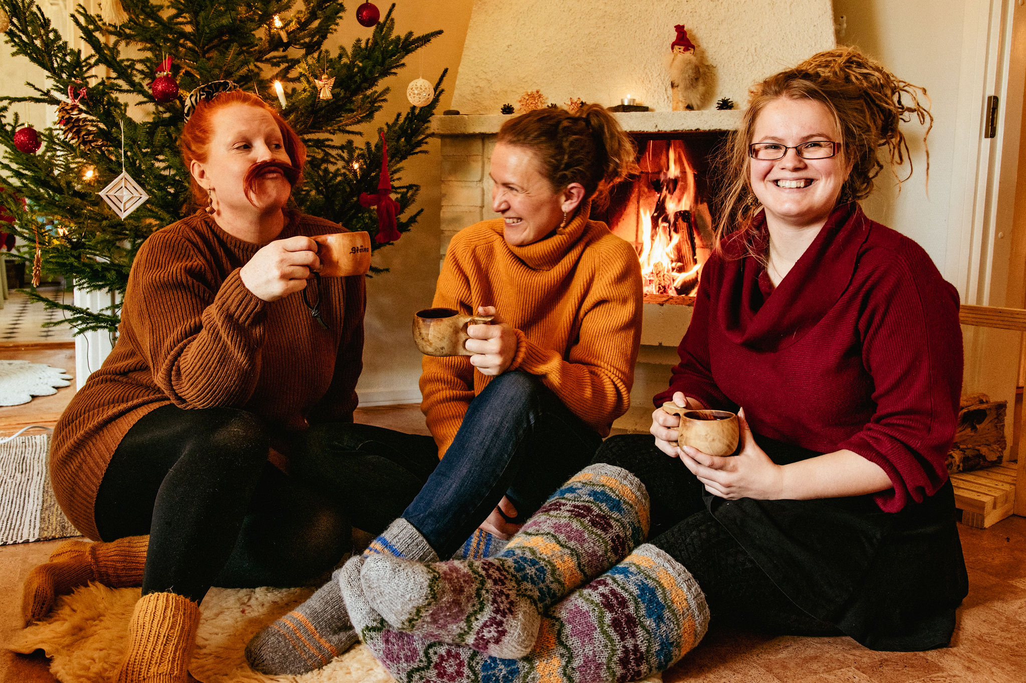 saimaaLife ladies Stiina, Mari and Marianne in Finland enjoying Christmas drinks by the fireplace