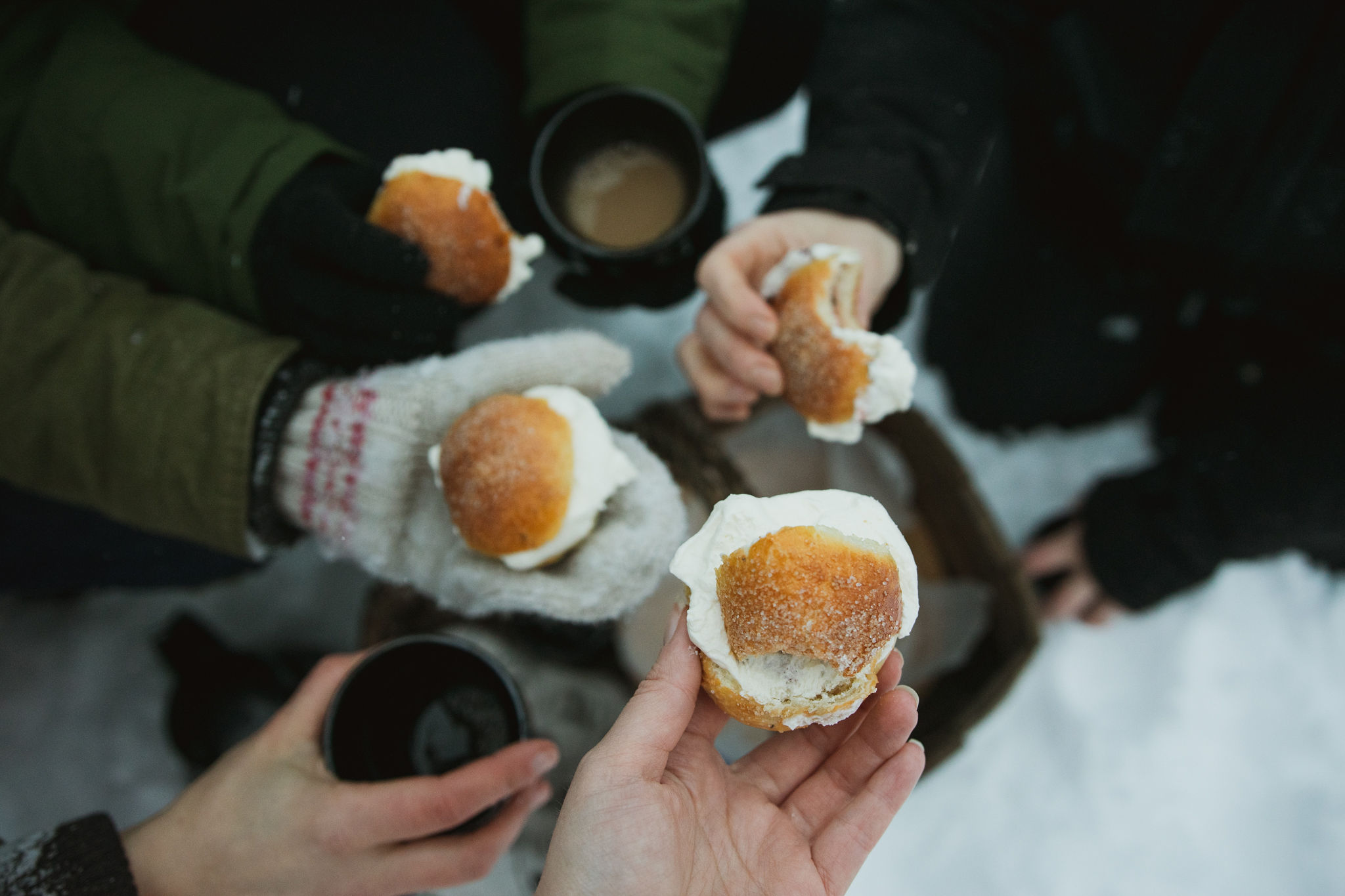 Finnish celebrating Shrovetide by eating buns outdoors in Finland